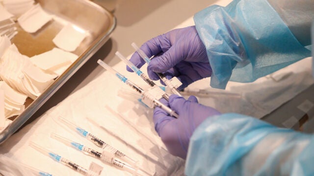 Un empleado sanitario sostiene una de las vacunas de Pfizer contra el Covid-19