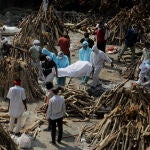GRAPHICS - 26 April 2021, India, New Delhi: People wearing personal protective equipment carry the body of a relative who died from the COVID-19 disease, before cremation at Ghazipur cremation ground in New Delhi. India saw a new global record of 352,991 daily new Covid-19 infections and 2,812 Covid-19 deaths on Monday as a second wave of the pandemic overwhelmed health systems. Photo: Naveen Sharma/SOPA Images via ZUMA Wire/dpa - ATTENTION: graphic contentNaveen Sharma/SOPA Images via ZU / DPA26/04/2021 ONLY FOR USE IN SPAIN