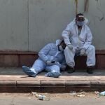 -FOTODELDIA- Nueva Delhi (India), 29/04/2021.- Dos paramédicos indios se toman un descanso a las puertas del depósito de cadáveres de un hospital en Nueva Delhi (India) este jueves. La India superó este jueves los 18 millones de casos tras batir un nuevo récord de infecciones, tras alcanzar casi los 380.000 contagios, además de contabilizar un nuevo máximo con más de 3.600 muertes en un día. EFE/IDREES MOHAMMED