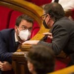 El vicepresidente de la Generalitat en funciones y candidato a la presidencia por ERC, Pere Aragonès, conversa con su compañero de partido Josep Maria Jové (d), en el pleno del Parlament.