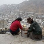 AME4669. LIMA (PERÚ), 03/05/2021.- Fotografía de archivo fechada el 1 de julio de 2020 que muestra dos mujeres que preparan una olla común en un cerro de la Nueva Rinconada, en Pamplona, un barrio del populoso distrito limeño de San Juan de Miraflores (Perú). Como hito del bicentenario de su independencia, que se celebra en 2021, Perú se propuso ingresar a la OCDE (Organización para la Cooperación y el Desarrollo Económicos), pero la inestabilidad y polaridad política de los últimos años y la gran recesión por la pandemia han roto ese sueño. EFE/Paolo Aguilar /ARCHIVO