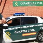 Un agente de la Guardia Civil, junto a un vehículo del cuerpo