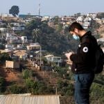Un trabajador de la ONG TECHO-Chile es visto junto a uno de los cerros poblados de viviendas del Campamento Felipe Camiroaga el 30 de abril de 2021, en la ciudad de Viña del Mar (Chile).