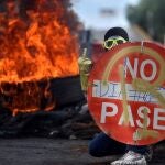 Un manifestante sostiene un aviso durante una protesta hoy en Cali (Colombia)