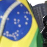 A supporter of Brazil's President Jair Bolsonaro wears a skull mask next to the Brazilian flag before the motorcycle rally with supporters representing the motoclubs in honor of Mother's Day, in Brasilia, Brazil, Sunday, May 9, 2021. (AP Photo/Eraldo Peres)