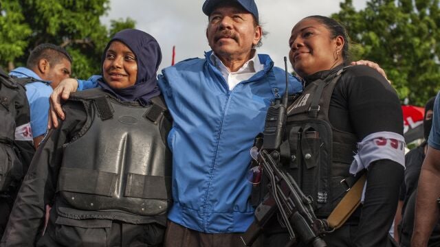 FILE - In this July 13, 2018 file photo, Nicaraguan police have their picture taken with President Daniel Ortega, after weeks of unrest in Masaya, Nicaragua. President Ortega is seeking a fourth consecutive term in November 2021, and he's pulling all the levers at his disposal to ensure his Sandinista National Liberation Front retains power. (AP Photo/Cristobal Venegas, File)