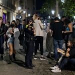 Una policía pide a una pareja que se ponga la mascarilla en la zona del Born, en el distrito de Ciutat Vella de Barcelona, el pasado fin de semana