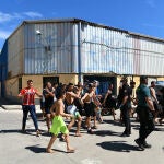 Un grupo de jóvenes inmigrantes marroquíes en fila en las inmediaciones de una nave, a 17 de mayo de 2021, en Ceuta 