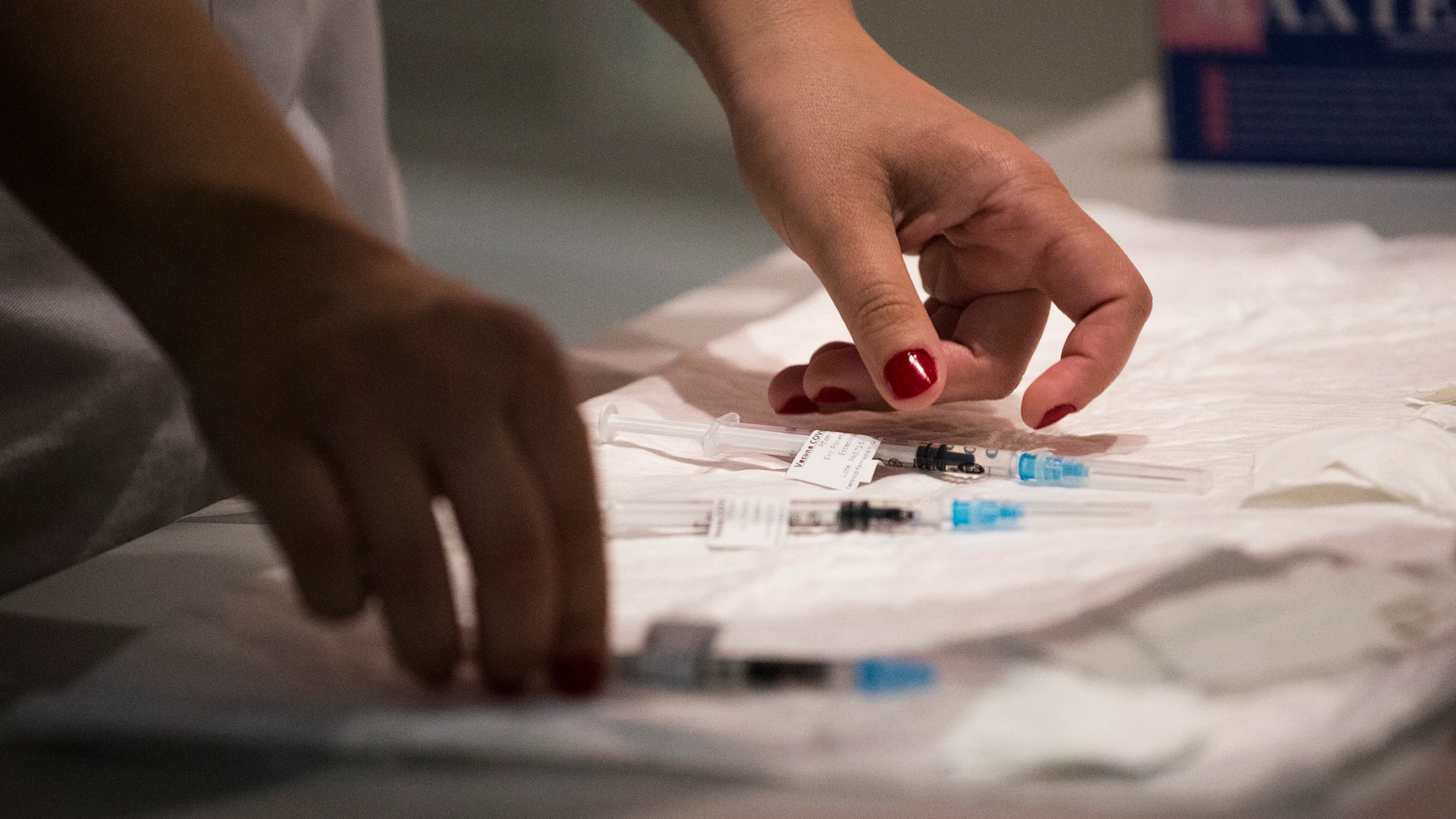 Una sanitaria prepara varias dosis de la vacuna de Pfizer en el Hospital Universitario de Getafe (Madrid)