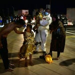 Un hombre migrante coge en brazos a un menor acompañado de una mujer y una niña pequeña, en Ceuta