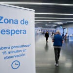 Un hombre entra en la zona de espera después de recibir la dosis con la vacuna de Pfizer en el Wanda Metropolitano de Madrid