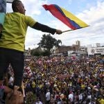 Un hombre sostiene una bandera colombiana durante las protestas en Cali