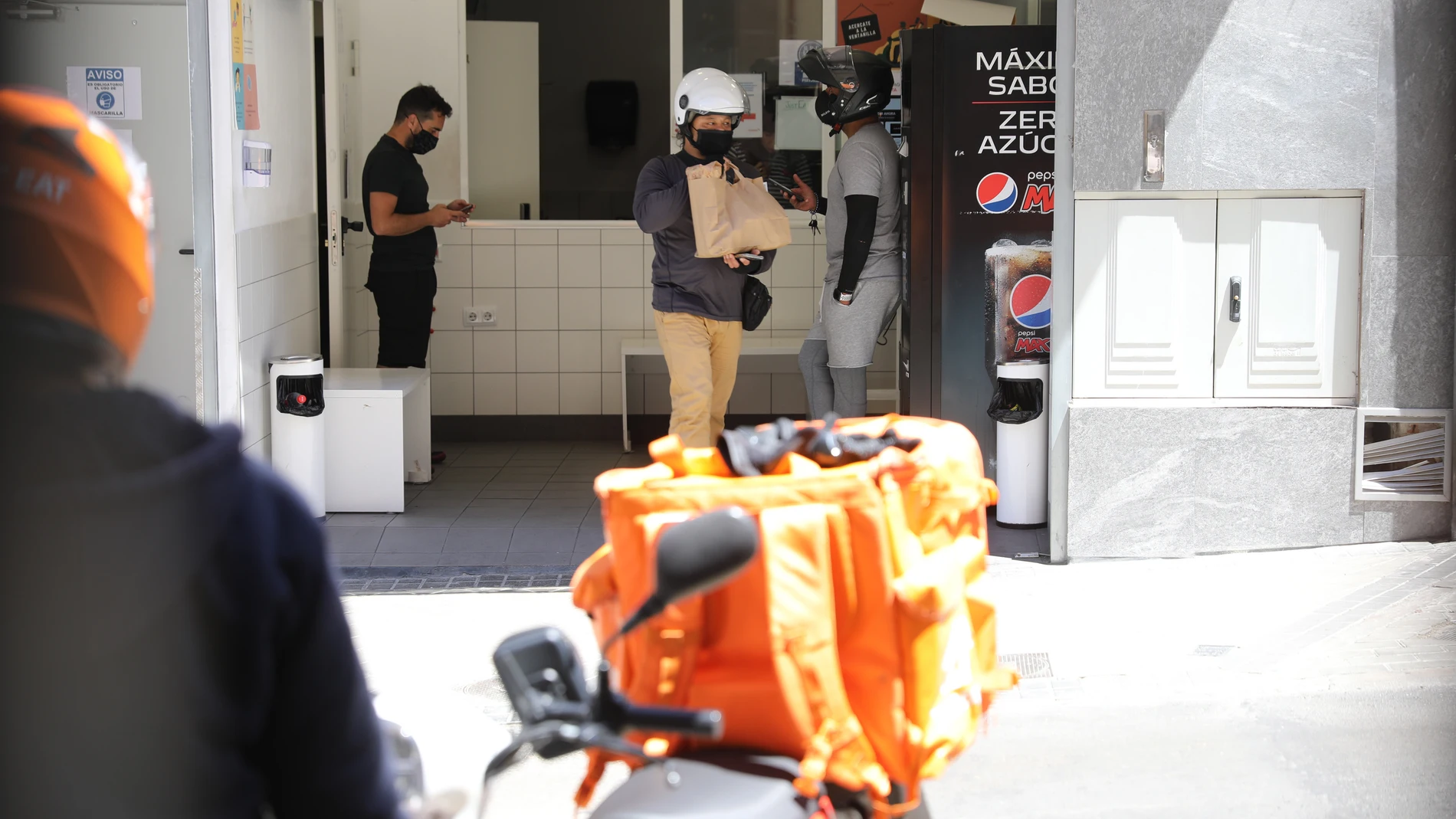 Repartidores recogen los pedidos en “cocinas fantasma“ en el madrileño distrito de Tetuán