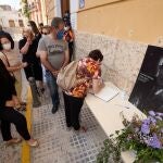 Una vecina de Oliva escribe en el libro de condolencias de la capilla ardiente con los restos mortales del poeta Francisco Brines, que el Ayuntamiento de Oliva ha abierto este sábado, poco después de las 10 horas