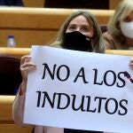 La senadora del PP, Cristina Ayala Santamaría, muestra un cartel en relación a su pregunta al ministro de Justicia, Juan Carlos Campo