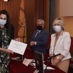 La consejera de Sanidad, Verónica Casado (D), entrega el premio al mejor artículo de Investigación realizado por personal facultativo a Tania Rodríguez Gabella (I), durante la entrega de los 'Premios anuales de investigación del Área de Salud Valladolid Este'