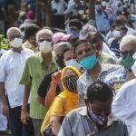 FILE - In this April 26, 2021, file photo, people queue up for coronavirus vaccine in Mumbai, India. The disparities of the coronavirus pandemic were already stark in India, where access to health care is as stratified and unequal as other parts of its society. Now, the divide along the lines of wealth and technology are further widening that chasm, and many people are falling through the gaps as vaccines remain inaccessible to millions. (AP Photo/Rafiq Maqbool, File)