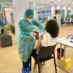 Una farmacéutica inyecta la vacuna a una compañera de profesión en el Colegio de Farmacéuticos de Madrid