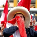 El candidato presidencial Pedro Castillo celebra junto a sus simpatizantes tras colocarse a la cabeza en el ajustado recuento de votos de las elecciones presidenciales, hoy, en las calles de Lima (Perú).