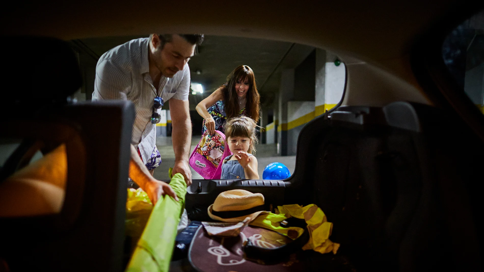 Una familia llenando el coche para irse de vacaciones