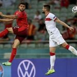 Loris Benito, a la izquierda, salta por un balón junto al turco Okay Yokuslu.