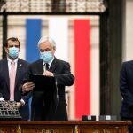 AME7291. SANTIAGO (CHILE), 20/06/2021.- Fotografía cedida por Presidencia de la República de Chile que muestra al presidente de Chile, Sebastían Piñera (c), mientras firma el decreto que convoca a la primera sesión de la Convención Constitucional encargada de la redacción y propuesta de una nueva Constitución. El mandatario esta acompañado por los ministros del Interior, Rodrigo Delgado (i), y del Secretario General de la Presidencia de Chile, Juan José Ossa (d), hoy en Santiago (Chile). Chile empezará a escribir su nueva Constitución el próximo 4 de julio, jornada en la que se celebrará la primera sesión de la Convención Constitucional, informó este domingo el presidente del país, Sebastián Piñera. EFE/Presidencia de la República de Chile /SOLO USO EDITORIAL/NO VENTAS/SOLO DISPONIBLE PARA ILUSTRAR LA NOTICIA QUE ACOMPAÑA/CRÉDITO OBLIGATORIO