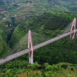 Los coches circularon por el puente Wulingshan de la autopista Chongqing-Hunan en el condado Qianjiang de Chongqing el 25 de abril de 2021. La autopista, de 848 kilómetros de longitud, conecta dos regiones pobres: el sureste de Chongqing y el oeste de la provincia de Hunan.