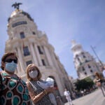 Dos mujeres caminan con mascarilla en la Gran Vía