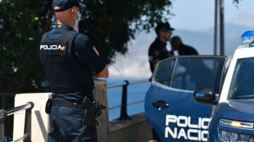 Un agente de polic&iacute;a nacional vigila en una zona rocosa de la playa, en una imagen de archivo