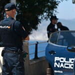 Un agente de polic&iacute;a nacional vigila en una zona rocosa de la playa, en una imagen de archivo