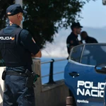 Un agente de policía nacional vigila en una zona rocosa de la playa, en una imagen de archivo