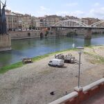Operarios y maquinaria, el lunes en la orilla del Ebro, frente al monumento