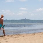 Un hombre camina en la playa del Mar Menor en Los Alcázares