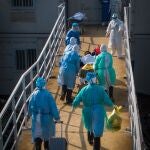 Esta imagen, captada el 4 de febrero de 2020, muestra personal médicoayudando a un paciente con COVID-19 a trasladarse a las salas deaislamiento del Hospital Huoshenshan (Montaña del Dios del Fuego), en Wuhan, capital de la provincia central china de Hubei