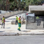 Varios obreros caminan por las inmediaciones de un edificio en construcción en Madrid