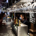 Una camarera atiende a un cliente durante la reapertura del Mercado de San Miguel, a 2 de julio de 2021, en Madrid, (Espa&ntilde;a).