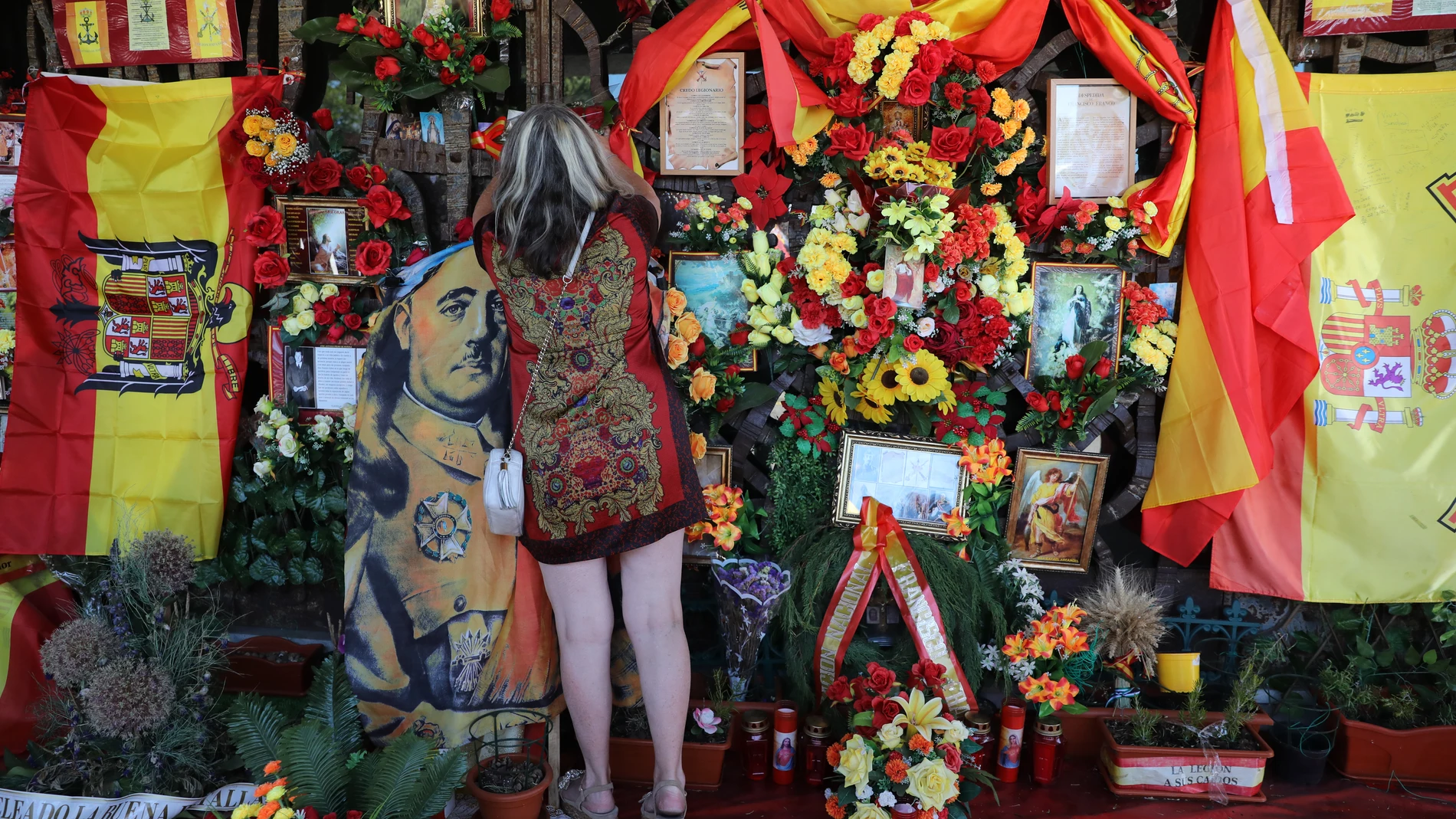 Una mujer deposita flores ante la tumba del dictador Francisco Franco, en el cementerio de Mingorrubio