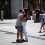 Una pareja de jóvenes en actitud cariñosa en la Puerta del Sol de Madrid