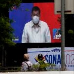 Manila (Philippines), 26/07/2021.- City cleaning workers watch a screen installed outside the Philippine Congress, showing Philippine President Rodrigo Duterte as he delivers his State of the Nation Address (SONA) in Quezon City, Metro Manila, Philippines 26 July 2021. President Duterte delivered, in front of the Philippine Congress, the last SONA of his six-year term on 26 July, amidst accusations from critics of human rights violations, mishandling of the COVID-19 pandemic and alleged inaction against China related to disputed waters in the West Philippine Sea. (Filipinas, Estados Unidos) EFE/EPA/ROLEX DELA PENA