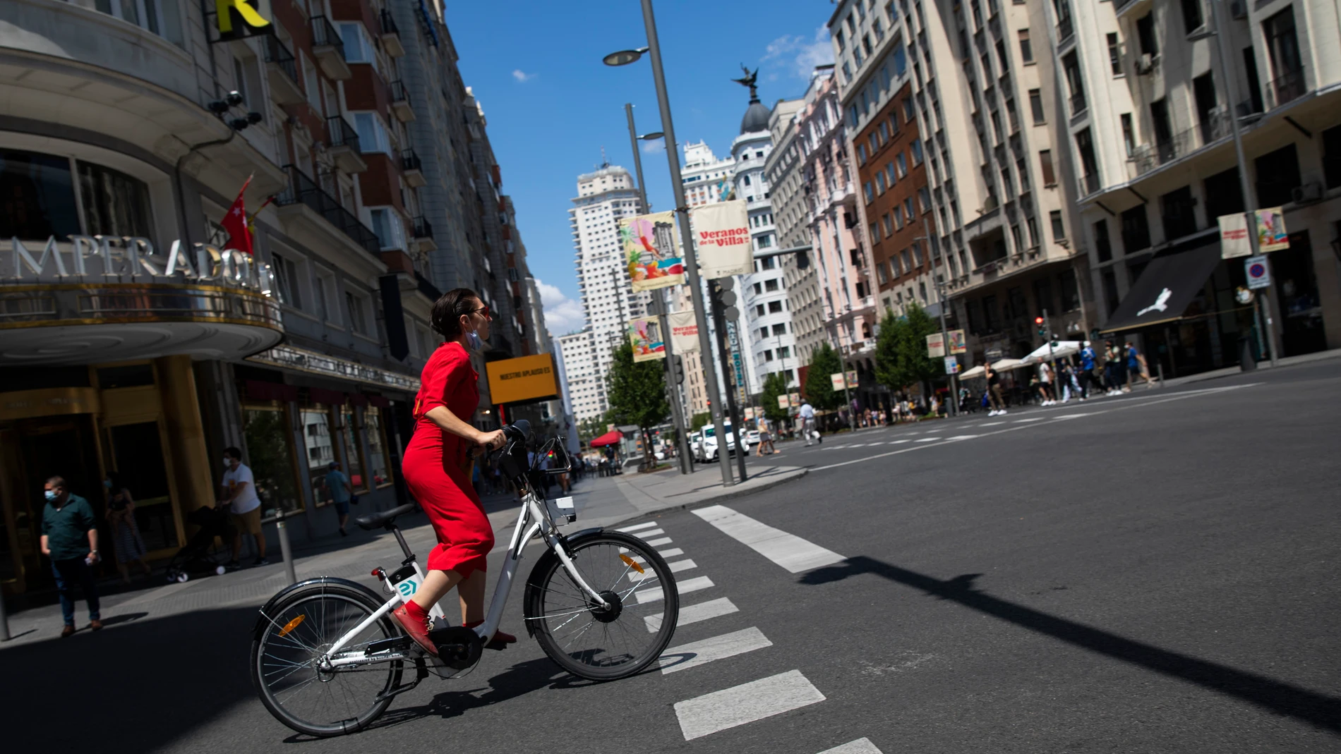 Imagen de una chica de rojo en bicicleta por la Gran Vía.