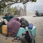 A migrant woman sleeps on a cement bench near the beach in Necocli, Colombia, Thursday, July 29, 2021. Migrants have been gathering in Necocli as they move north towards Panama on their way to the U.S. border. (AP Photo/Ivan Valencia)