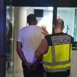 Uno de los detenidos es conducido por la Policía