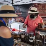 Tourists look at cigars for sale at the Old San Juan dock after the arrival of Carnival's Mardi Gras cruise ship in San Juan, Puerto Rico, Tuesday, Aug. 3, 2021, marking the first time a cruise ship visits the U.S. territory since the COVID-19 pandemic began. (AP Photo/Carlos Giusti)