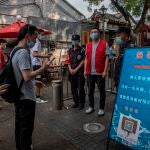 Gente con mascarillas para entrar en un mercado en China