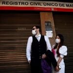 Rafael y Miki, protegidos con mascarillas, esperan para contraer matrimonio a las puertas del Registro Civil de Madrid. A 11 de agosto de 2021