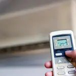 ¡Una persona enciende un aparato de aire acondicionado