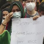 An Afghan woman weeps as she holds a poster during a rally outside the building that houses UNHCR representative office in Jakarta, Indonesia, Tuesday, Aug. 24, 2021. Hundreds of Afghan refugees living in Indonesia, mostly members of the Hazara ethnic minority, held the rally on Tuesday decrying the Taliban's takeover of their country and calling for resettlement in third countries. (AP Photo/Tatan Syuflana)