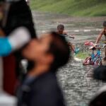 Una mujer se somete a una prueba de antígeno en una calle de Manila con dos niños al fondo