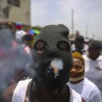 FILE - In this July 26, 2021 file photo, a member of the gang led by Jimmy Cherizier, alias Barbecue, a former police officer who heads a gang coalition known as "G9 Family and Allies,Â¨ joins a march to demand justice for slain Haitian President Jovenel in Lower Delmas, a district of Port-au- Prince, Haiti. Haiti's government warned Monday, Sept. 6, 2021, about a spike in kidnappings and other crimes as it pledged to fight gangs that in response to the looming crackdown are threatening police with greater violence as the country braces for more instability. (AP Photo/Joseph Odelyn, File)