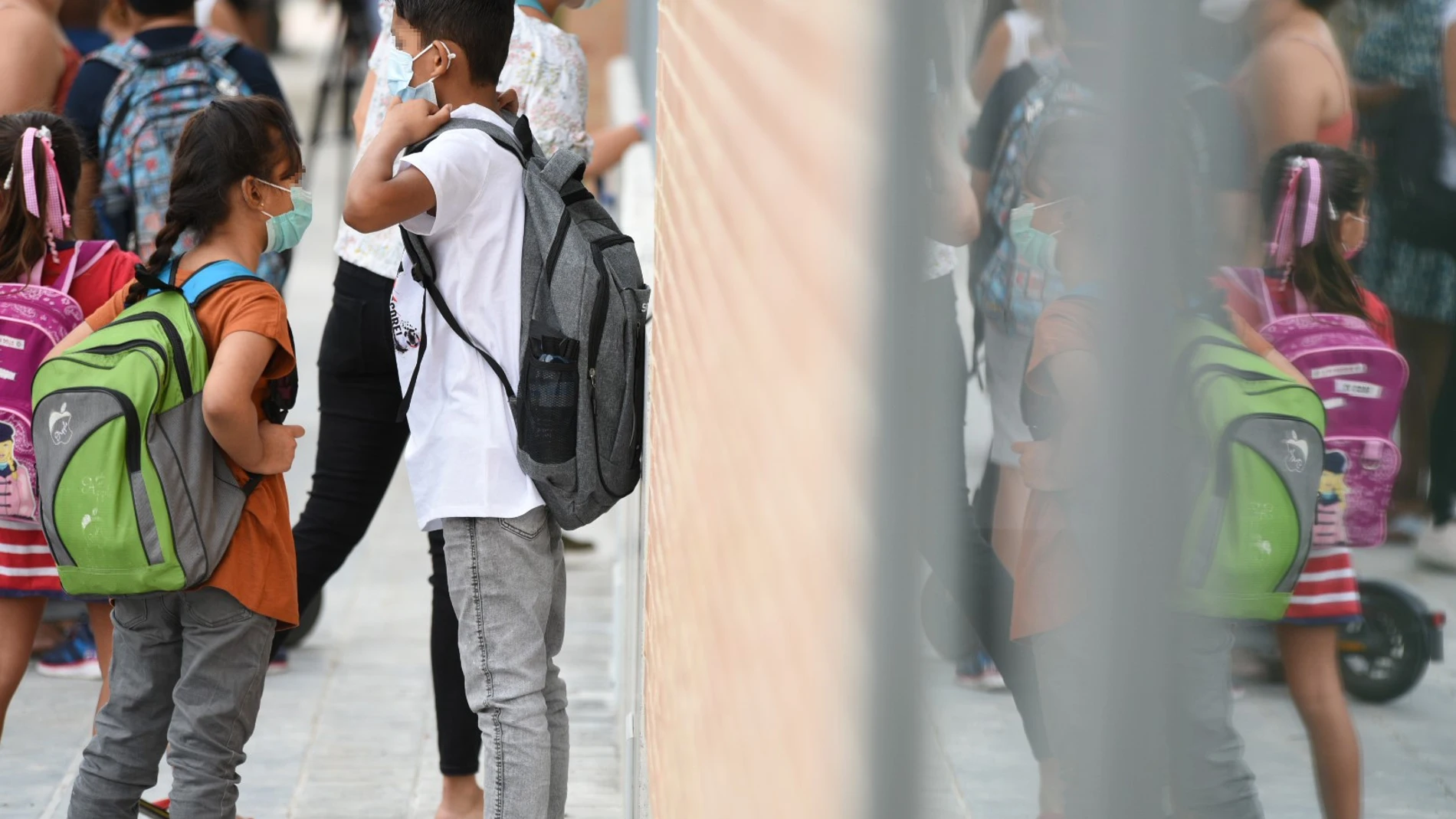 Varios niños esperan a la puertas del colegio Les Arts, de reciente construcción, durante el primer día del curso escolar 2021-2022 en la Comunidad Valenciana